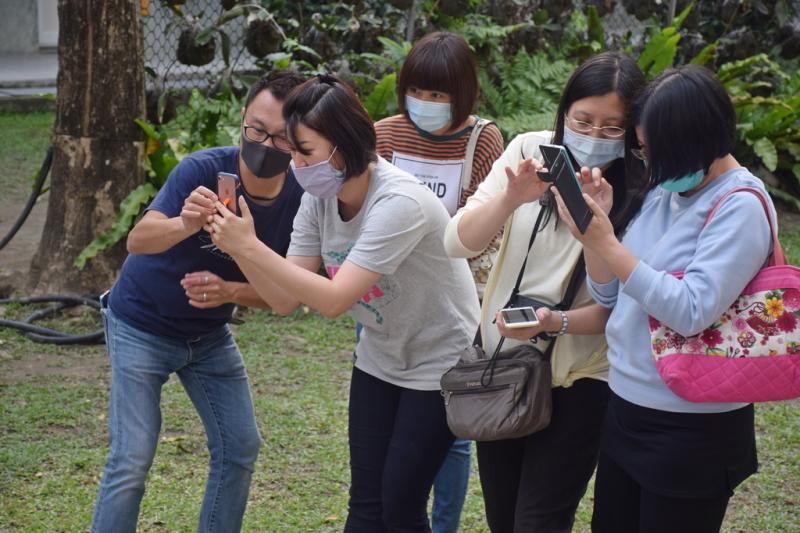 老師觀看學員戶外拍攝效果。