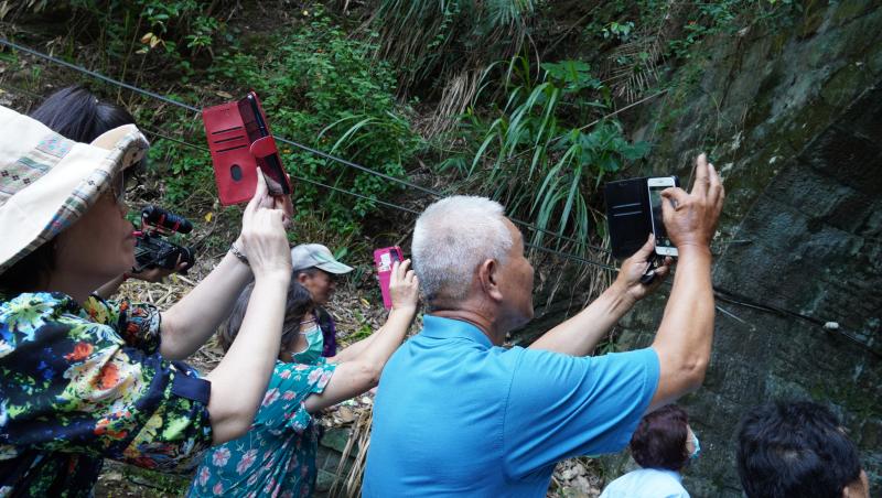 <p>水里DOC開設紀錄車埕課程，學員拿著手機拍攝與紀錄舊水里火車隧道。</p>