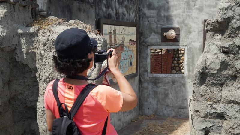 <p>學員參與社區走讀課程，用相機攝影紀錄舊時為防止東北季風帶來的泥沙侵擾，居民築起一道防沙牆，如今以藝術形式的陶板畫呈現「時光廊道」述說大安港的神蹟故事～</p>