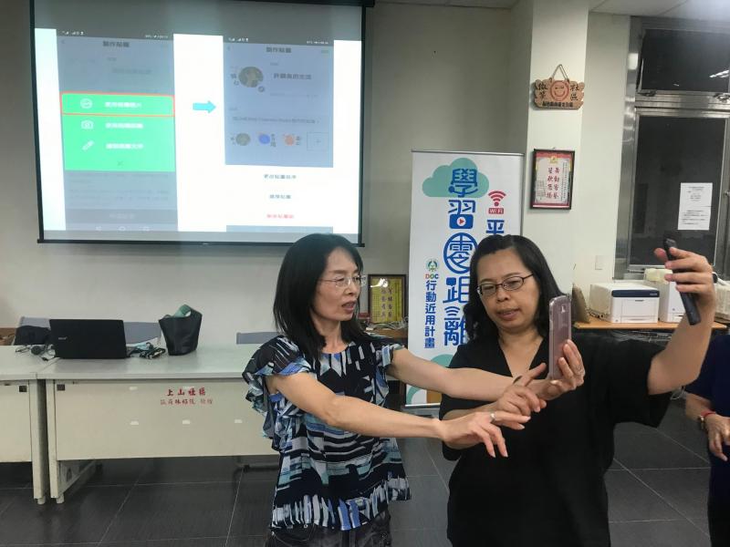 沛晴老師指導學員秀茸姐如何利用手機取角度拍出最佳照片。