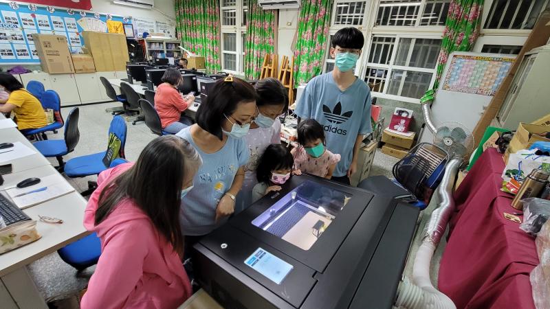 老師操作機台學員觀看雕刻機雕刻情形。