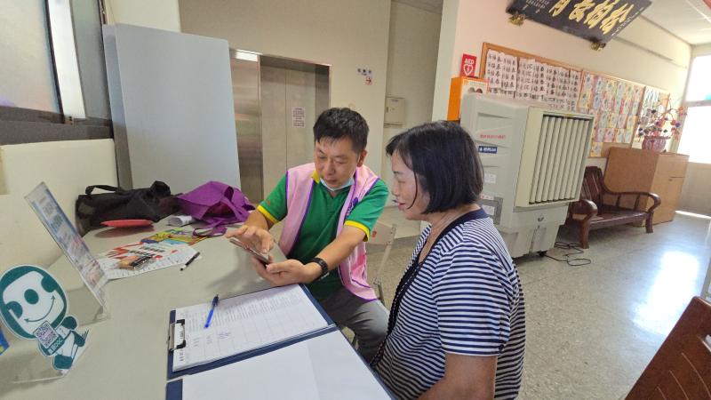 在攤位前請問老師手機遇到的問題。