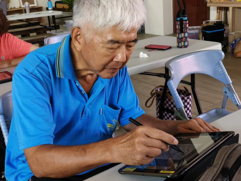 邱大哥參與「大地採集—我是公民科學家」課程，正在用平板繪製出印象最深刻的植物。