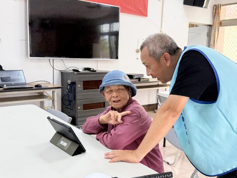 <p>社區長者透過平板電腦觀賞數位走讀影片，長輩一邊觀看、一邊交流過往記憶，重新認識熟悉的街角與風景。</p>