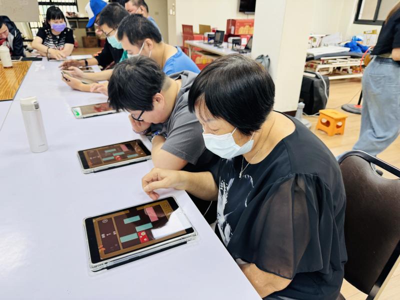 <p>身障協會的成員們一人一台平板，低頭專注地慢慢點、慢慢學。一打開螢幕，大家就被療癒的數位世界深深吸引，玩得投入又專心。這堂安靜的課，讓他們能幸福地在教室裡笑著學習，用數位陪伴帶來滿滿的快樂與力量。</p>