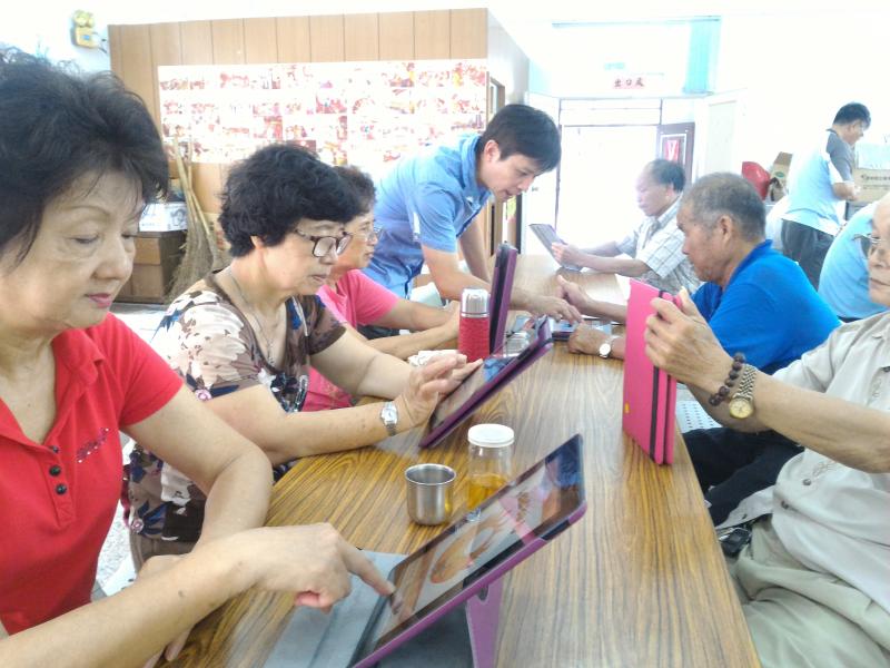 富收村民體驗平板的操作，如何將個人照片美化加入裝飾