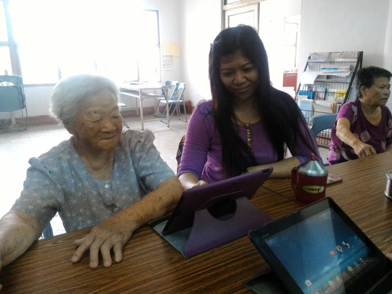 新住民陪伴阿嬤互動學習，指導阿嬤拍照及小遊戲的體驗