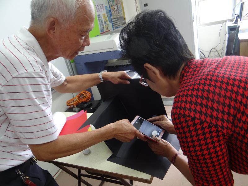 利用自製小攝影棚，讓學員實作練習拍照。