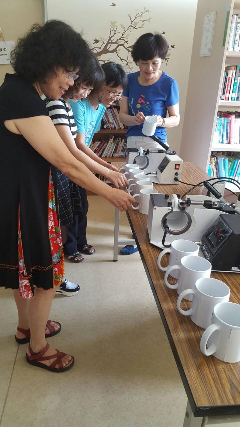 學員將電腦排版的圖案轉印到馬克杯