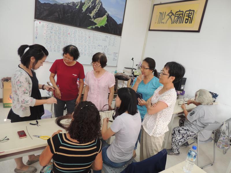 製作花藍外圈花式過程。民眾查看老師製作過程