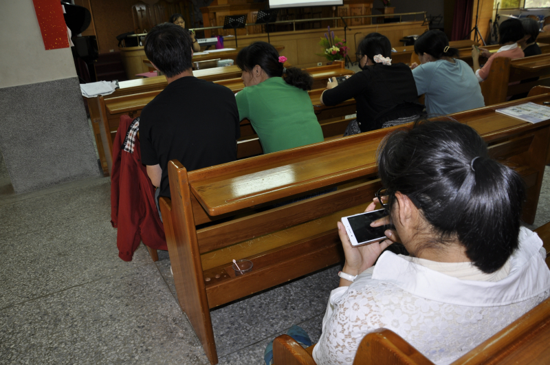 老師教導學員利用手機下載威力導演APP，製作祝賀母親節的影音短片。