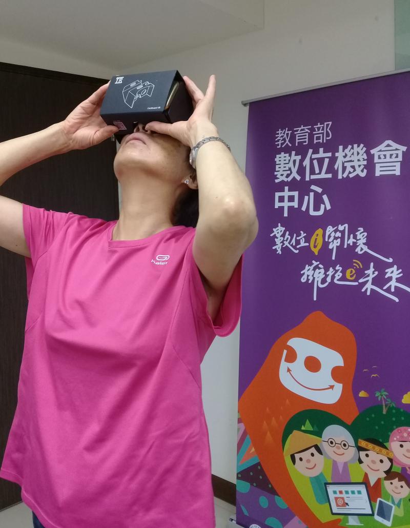 一位阿嬤正在體驗VR設備，並將她的頭抬起