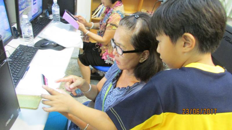 小朋友幫年紀大的奶奶操作測量。