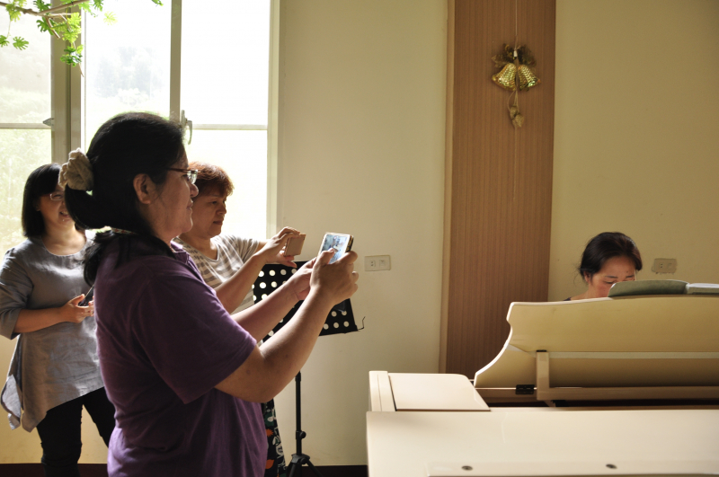 學員體驗臉書直播功能，學員雅大諾莉為女主角，負責彈琴，其他學員負責直播操作。