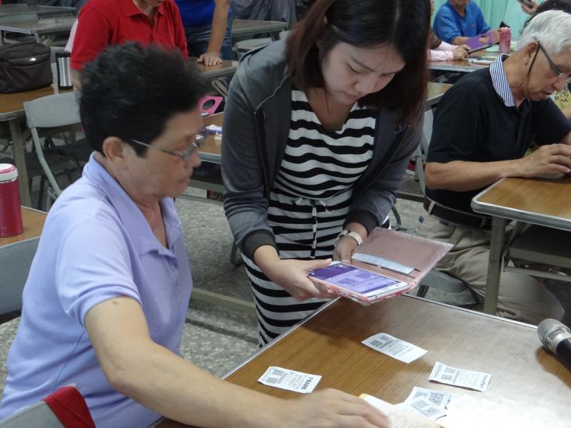 講師一旁指導學員使用平板如何下載APP