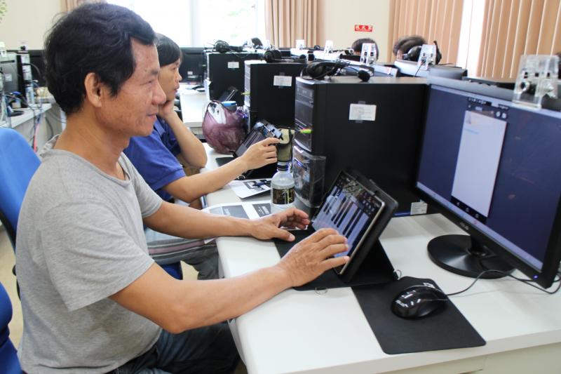 學員看著老師的教學彈奏鋼琴