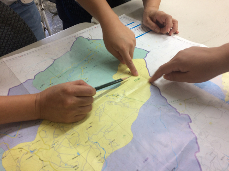 拿著萬里行政區的地圖，討論著地圖的範圍。