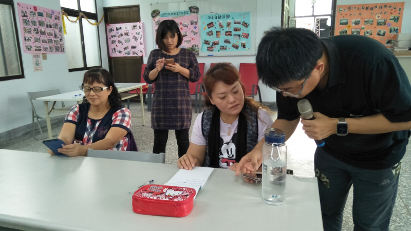 講師指導學員操作智慧型手機。