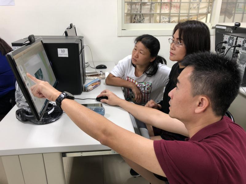 老師指著螢幕幫助學員使用簡報的功能