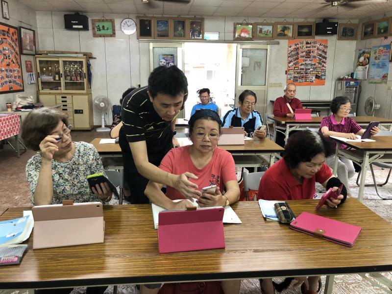 學員看著老師示範怎麼操作平板