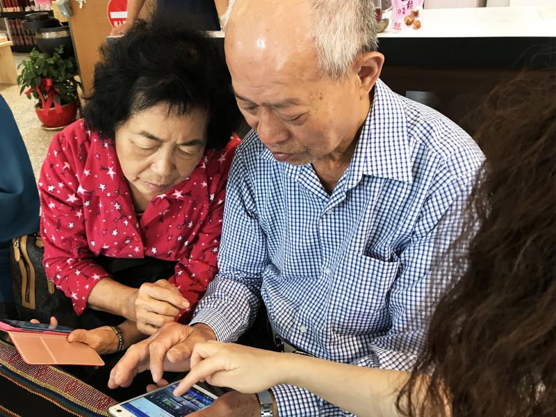 兩位學員彼此交流，討論如何操作手機軟體