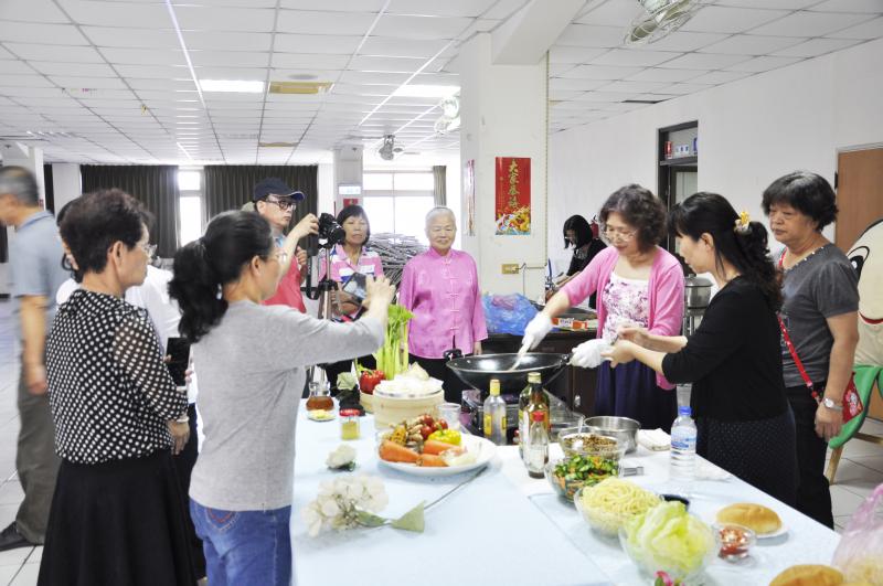 示範講師陳小玲，領著學員示範烹飪教學操作，一方面烹飪並解說、一方面配合攝影紀錄，學員展現極佳的合作默契。 