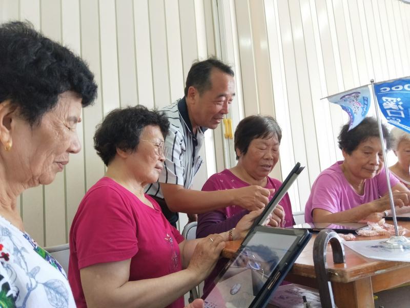 老師教學員使用平板電腦，先熟悉手感再進行課程活動。