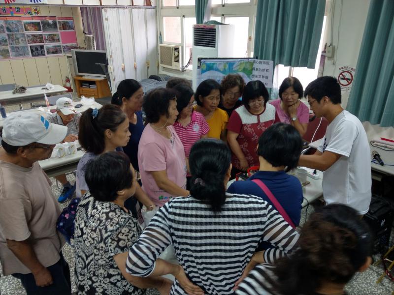 學員圍著講師專心聆聽講解