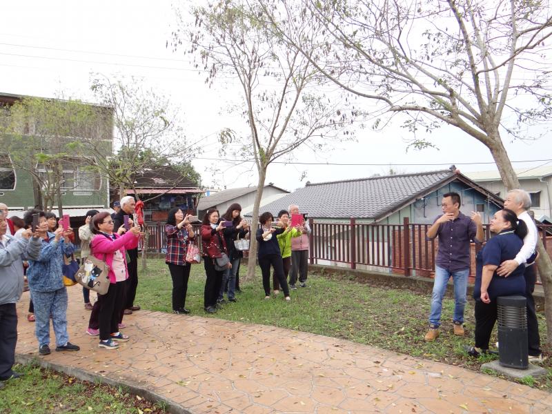 學員實際操作戶外人物照，要注意是否背光，講師一旁指導著大家。