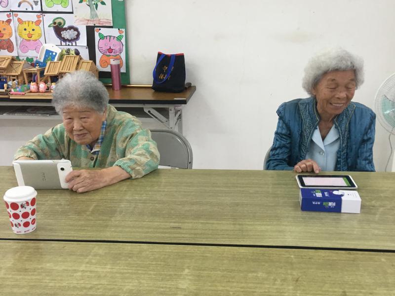 婆婆媽媽暖圖有夠讚課程，學員拿著手機認真操作與練習。