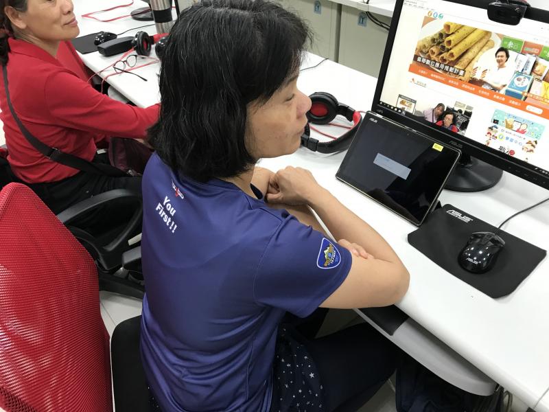 學員認真看老師操作平板示範如何開啟學習平台。