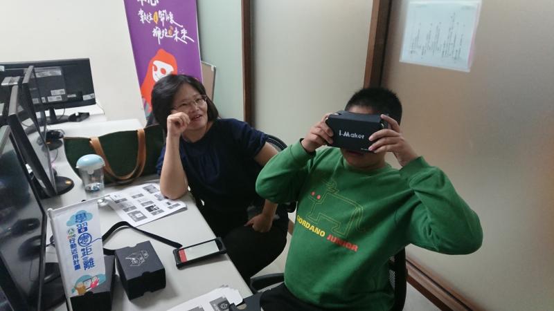 身穿綠色上衣的學員正嘗試以數位機會中心提供的設備拍攝教室四週的環景。