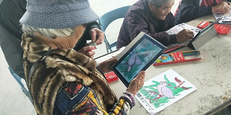 一位學員將自己塗好顏色的白鳥，用AR的程式以3D立體投影出，呈現在螢幕上。