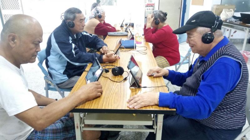 學員們將平板立於桌上，戴上耳機學習使用youtube。