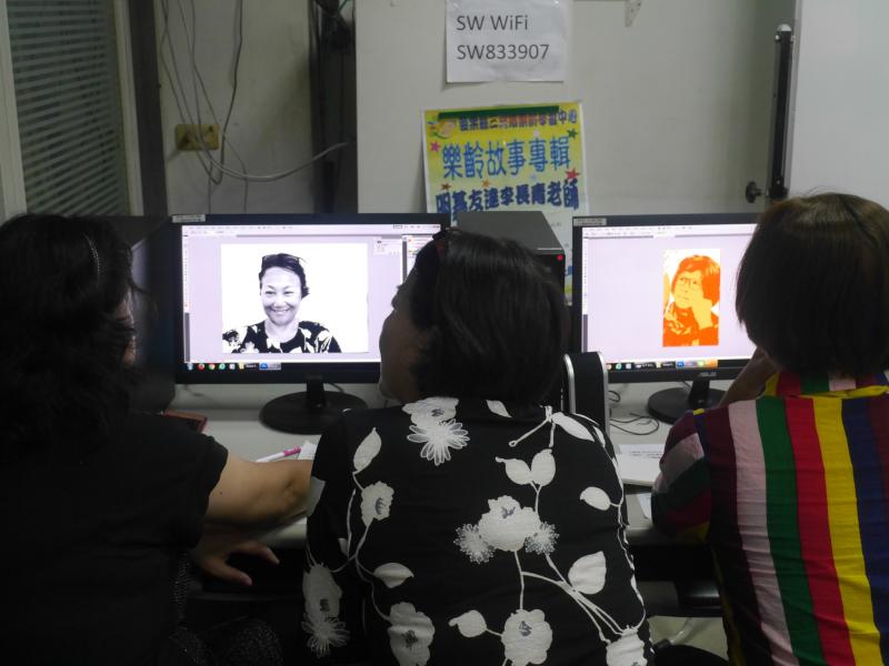 學員們在電腦前擠在一起，用Photoshop修改自己的圖像