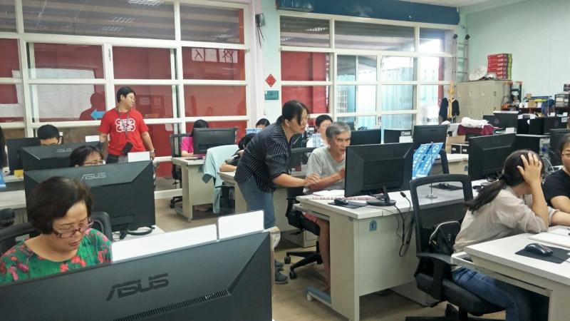 講師站在學員右邊，教導使用GOOGLE雲端硬碟開啟同步處理。