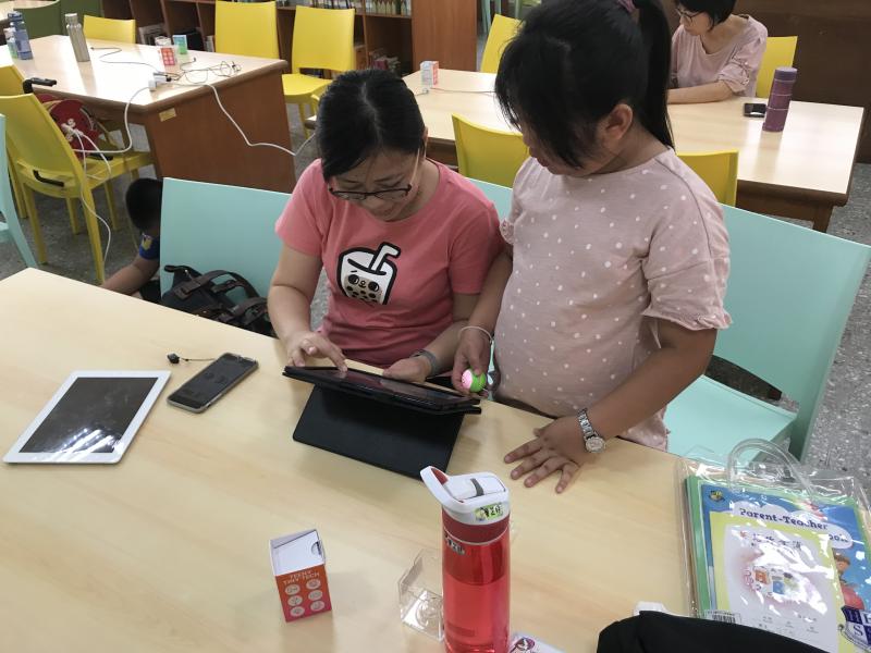 學員媽媽與孩子一同操作機器球，設關卡，準備闖關遊戲