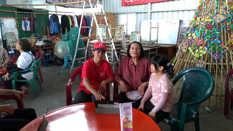 正逢暑假期間，孫女陪同長輩上課，並在旁教阿公阿嬤操作平板。