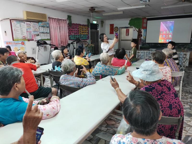 學員專注地跟著講師一起操作手機