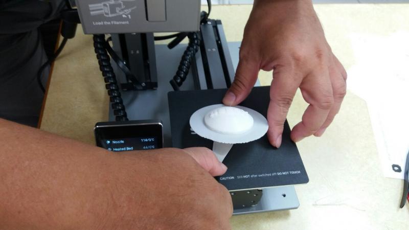 將完成的作品從3D列印機的面板上取下來