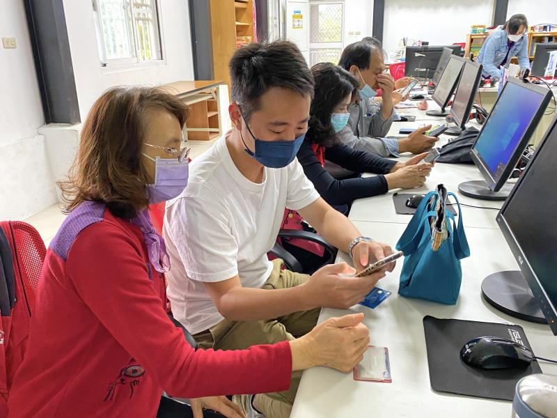 學員們認真操作手機，依照講師的步驟綁定行動支付