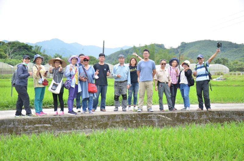 竹君老師與學員一起在綠色的稻田前合影
