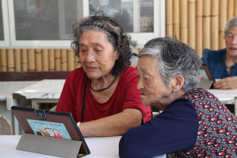 部落長輩學習使用平板觀看 YouTube 查找新聞、喜歡的歌曲。