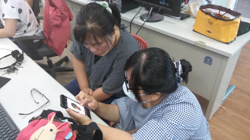 講師使用學員手機示範貼圖製作過程，協助學員完成第一套貼圖