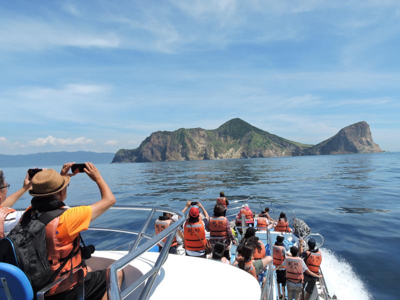 DOC學員不怕日曬及浪花，在船上聚焦不遠處的龜山島拍攝。