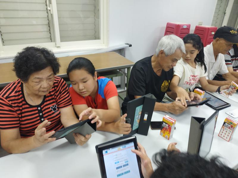 小朋友協助長輩操作平板