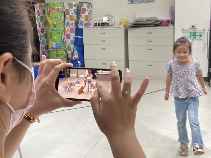 媽媽協助引導小朋友結合擴增實境，拍出互動照片