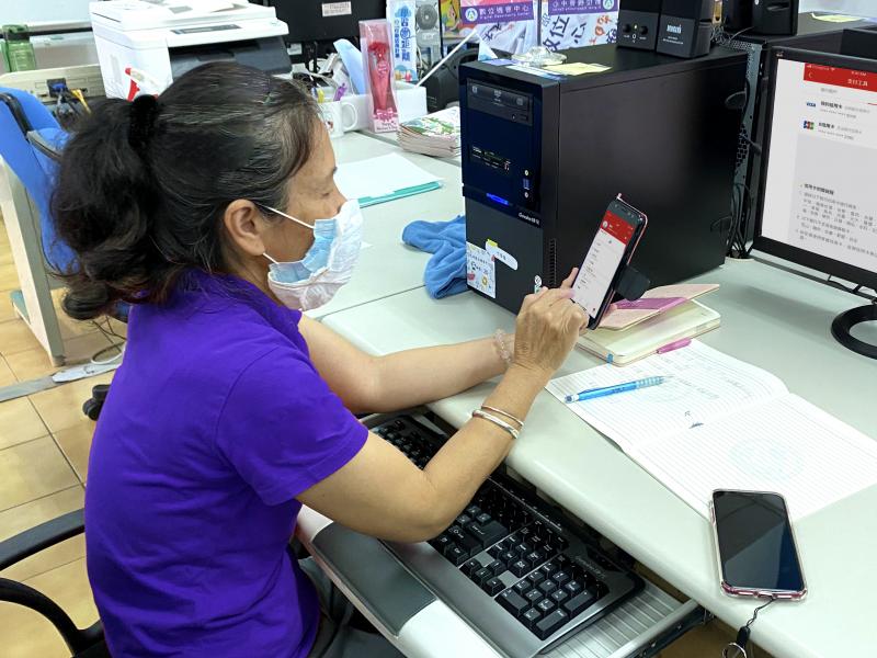 學員拿手機學習操作行動支付APP