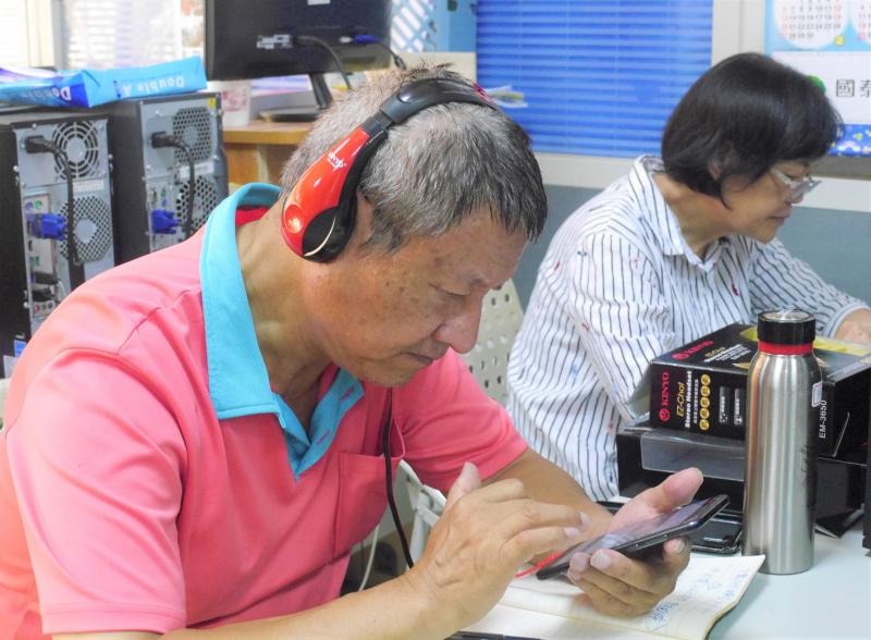 學員們戴著耳機，用手機專心剪輯