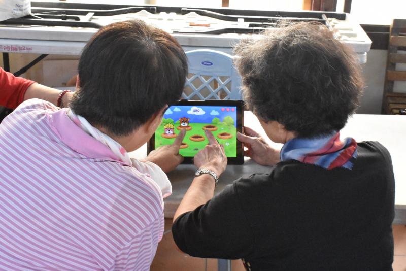 2位新光樂社區齡學員一起共玩一台平板電腦體驗Piano Kids-Music APP遊戲